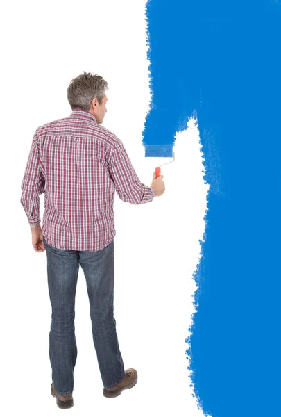 Senior adult painting wall in blue — Stock Photo, Image
