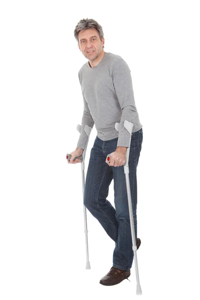 Hombre mayor caminando con muletas — Foto de Stock