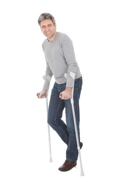 Senior man walking using crutches — Stock Photo, Image