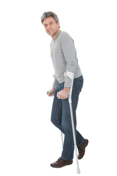 Senior man walking using crutches — Stock Photo, Image