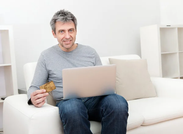 Senior man shopping at home using laptop — Stock Photo, Image