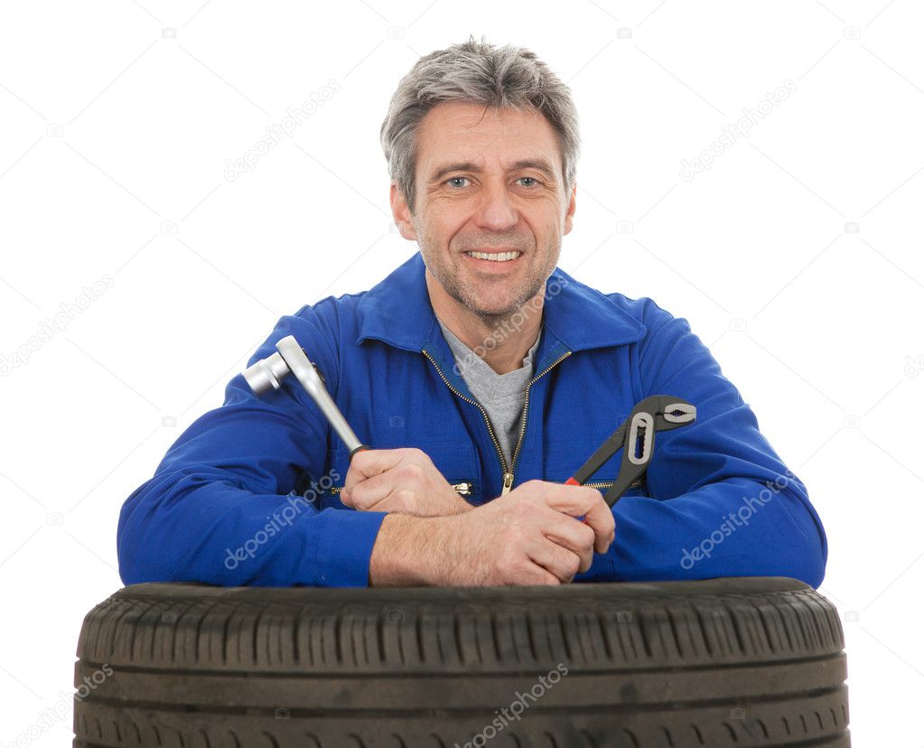 Automechanic leaning on car tires