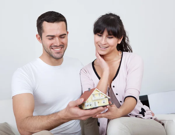 Gelukkige jonge paar bezit een huis-model — Stockfoto