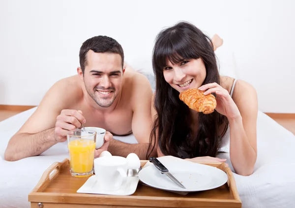 Fiatal pár az ágyban reggelizés — Stock Fotó