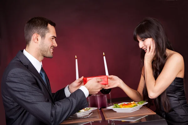 Чоловік дарує подарунок жінці в ресторані — стокове фото