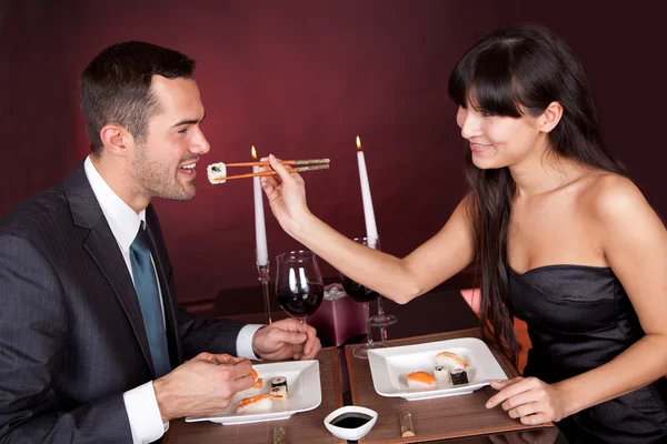 Νεαρό ζευγάρι τρώει σούσι στο εστιατόριο — Φωτογραφία Αρχείου