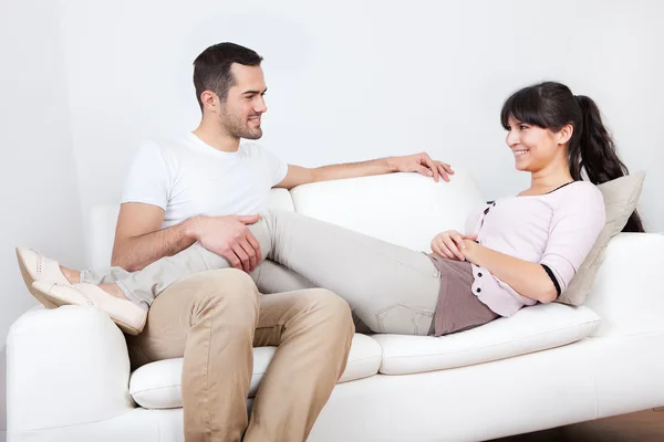 Happy young couple lying it the couch — Stock Photo, Image