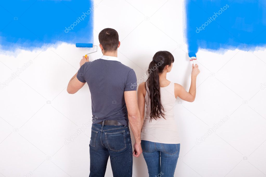 Couple painting wall at home