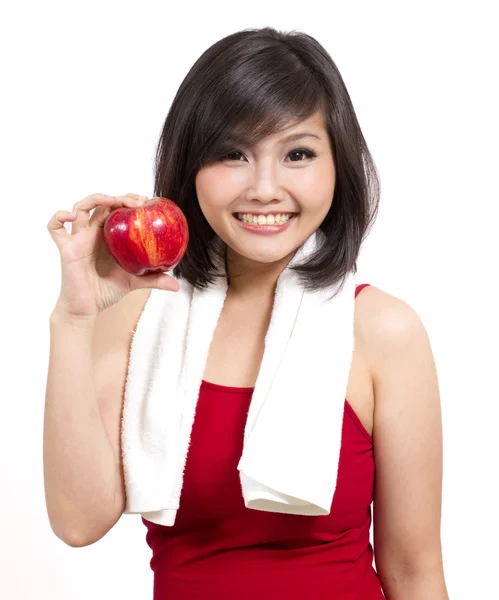 Красивая молодая женщина с яблоком и полотенцем после тренировки — стоковое фото