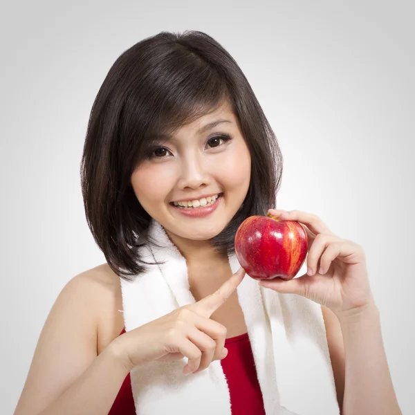 Pretty young female with apple and towel after exercise — Stock Photo, Image