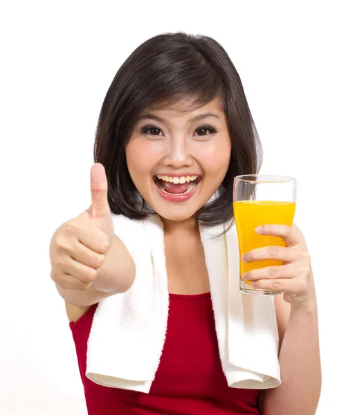 Menina asiática bonita segurando suco de laranja e polegares para cima — Fotografia de Stock