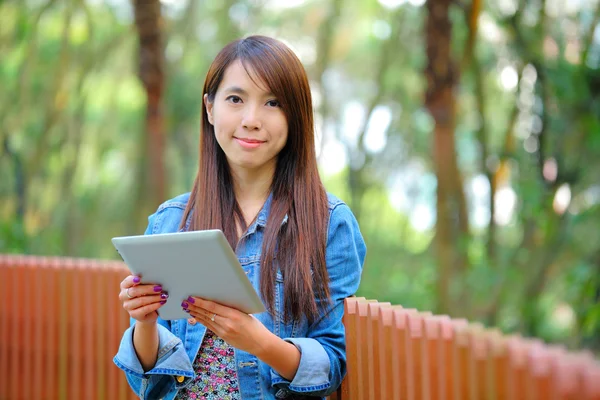 Mladá asijská žena s tabletovým počítačem venkovní — Stock fotografie