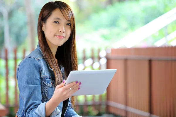 Молодая азиатка с планшетным компьютером на открытом воздухе — стоковое фото