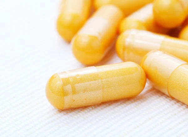 Comprimidos amarelos, cápsulas — Fotografia de Stock
