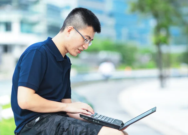 Ung man använder laptop utomhus — Stockfoto