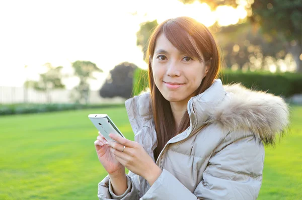 Young woman with phone outdoors — Stock Photo, Image
