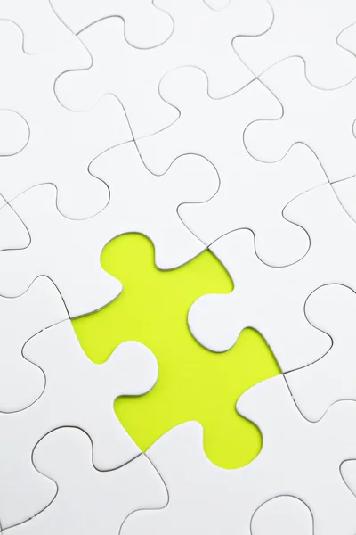Jigsaw puzzle with green piece missed — Stock Photo, Image