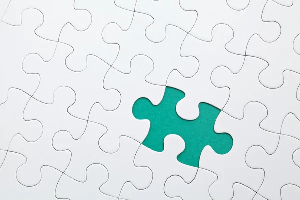 Puzzle with green piece missed — Stock Photo, Image