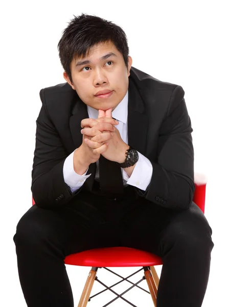 Молодой азиатский бизнесмен думает: — стоковое фото