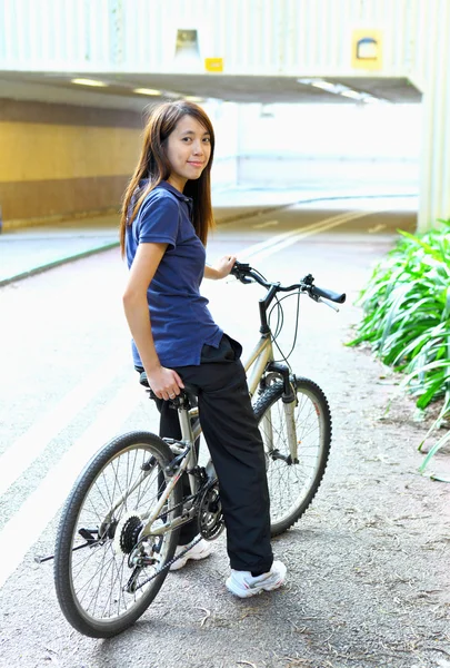 Jeune femme à vélo en ville — Photo