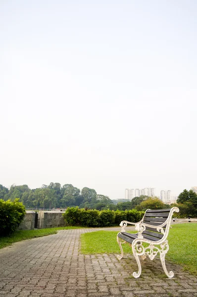 Скамейка в парке с копировальным пространством в небе — стоковое фото