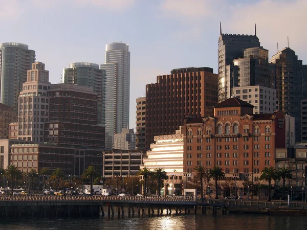 San Francisco Pier og Cityscape som stigende sol reflekterer over bygge - Stock-foto