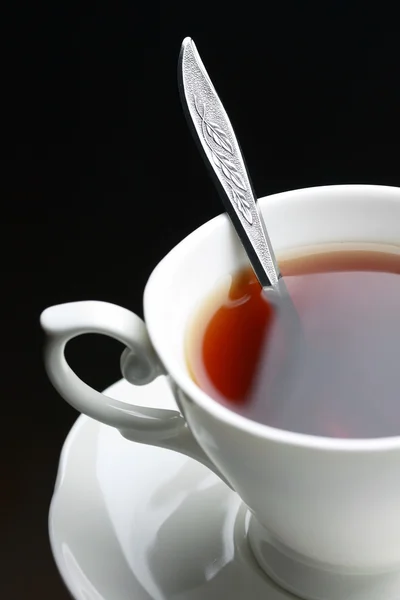 Полная чашка чая с ложкой — стоковое фото