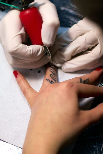 Fazer uma tatuagem em dedos femininos — Fotografia de Stock