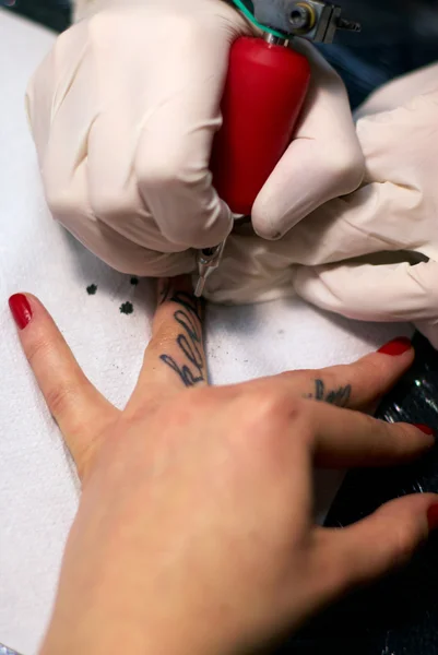 Maken van een tatoeage op vrouwelijke vingers — Stockfoto