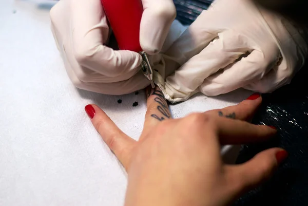 Maken van een tatoeage op vrouwelijke vingers — Stockfoto