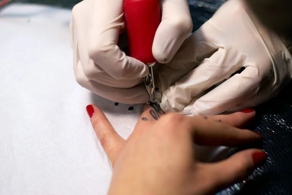 Making a tattoo on female fingers — Stock Photo, Image