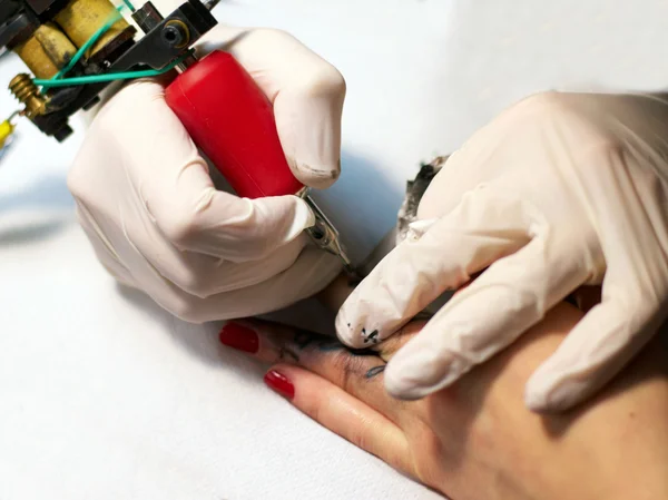 Making a tattoo on female fingers — Stock Photo, Image