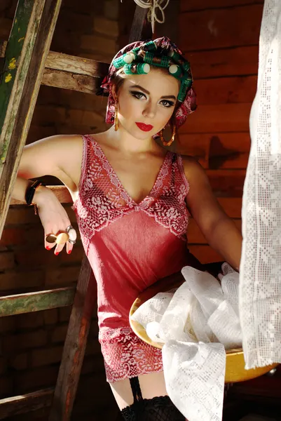Pin up girl on the attic in lingerie with curlers — Stock Photo, Image