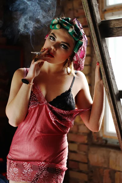 Fumar pin up menina no sótão em lingerie com encrespadores — Fotografia de Stock