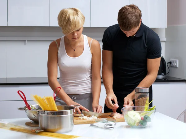 Couple in their kitchen making dinner — Stock Photo, Image