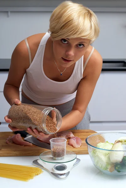 Pretty blond girl in the kitchen making pasta — Stock Photo, Image