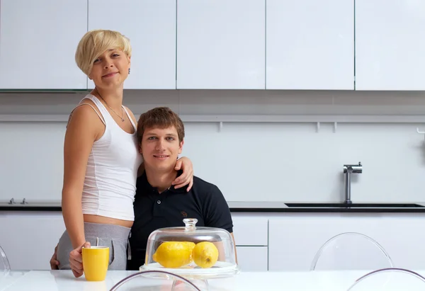 stock image Happy couple posing in the kitchen with cups and lemons