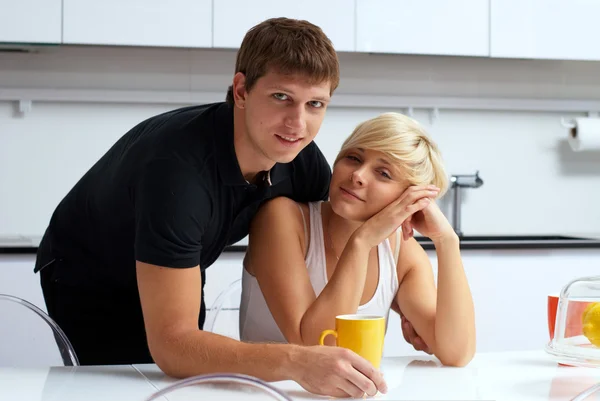 Lyckliga par poserar i köket med koppar och citroner — Stockfoto