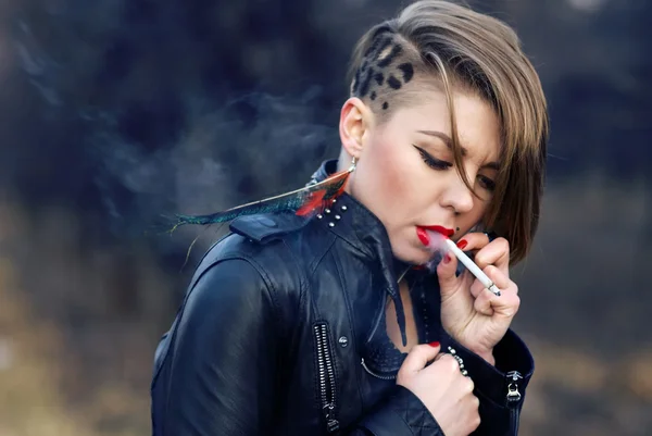 Блондинка-хипстер с леопардовой стрижкой курит сигарету в одиночестве — стоковое фото