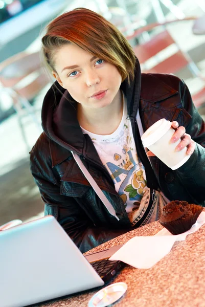 Porträt eines Mädchens mit Tasse und Muffin auf der Terrasse des Schnellrestaurants — Stockfoto