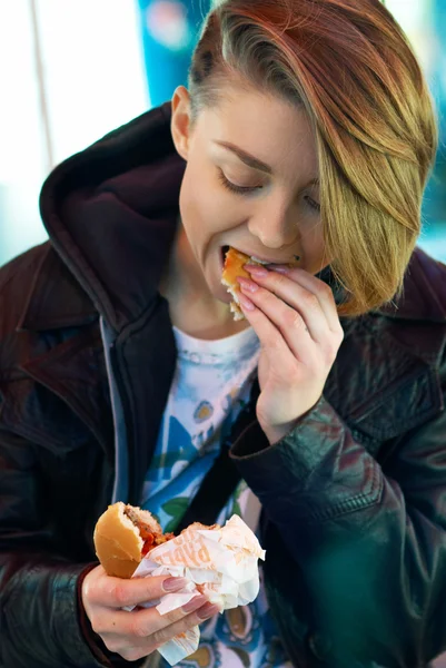 Portrait of girl with eats burger on the terrace of the fast foo — Stock Photo, Image