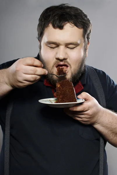 Vicces kövér fickó eszik csokoládé torta — Stock Fotó