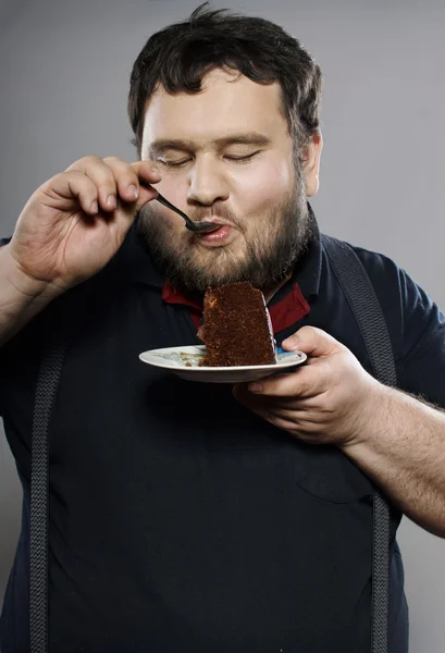 Funny fat guy eating chocolate cake — Stock Photo, Image