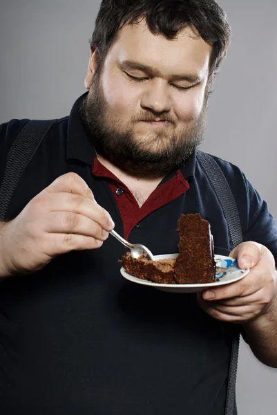 Funny fat guy eating chocolate cake — Stock Photo, Image