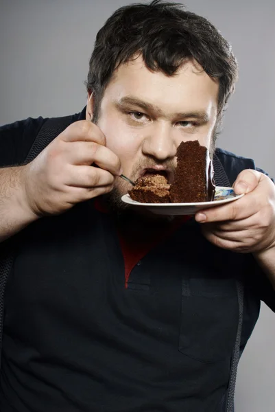 Roliga Fet kille äta chokladkaka — Stockfoto