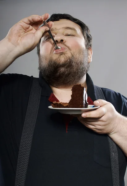 Roliga Fet kille äta chokladkaka — Stockfoto
