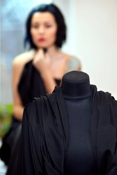 Schaufensterpuppe mit schwarzem Tuch umwickelt mit Mädchen auf dem Hintergrund i — Stockfoto