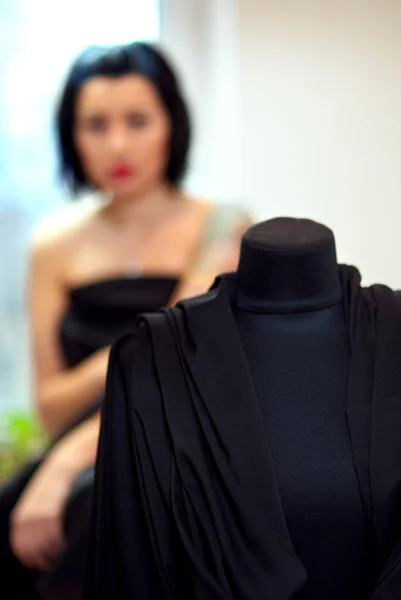 Etalagepop omwikkeld met zwarte doek met meisje op de achtergrond ik — Stockfoto