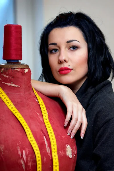 Näherin mit roter alter Schaufensterpuppe und Maßband in ihrer Arbeit — Stockfoto