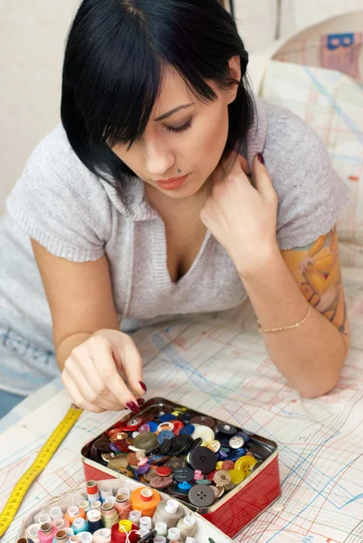 Young seamstress choosing buttons — Stock Photo, Image